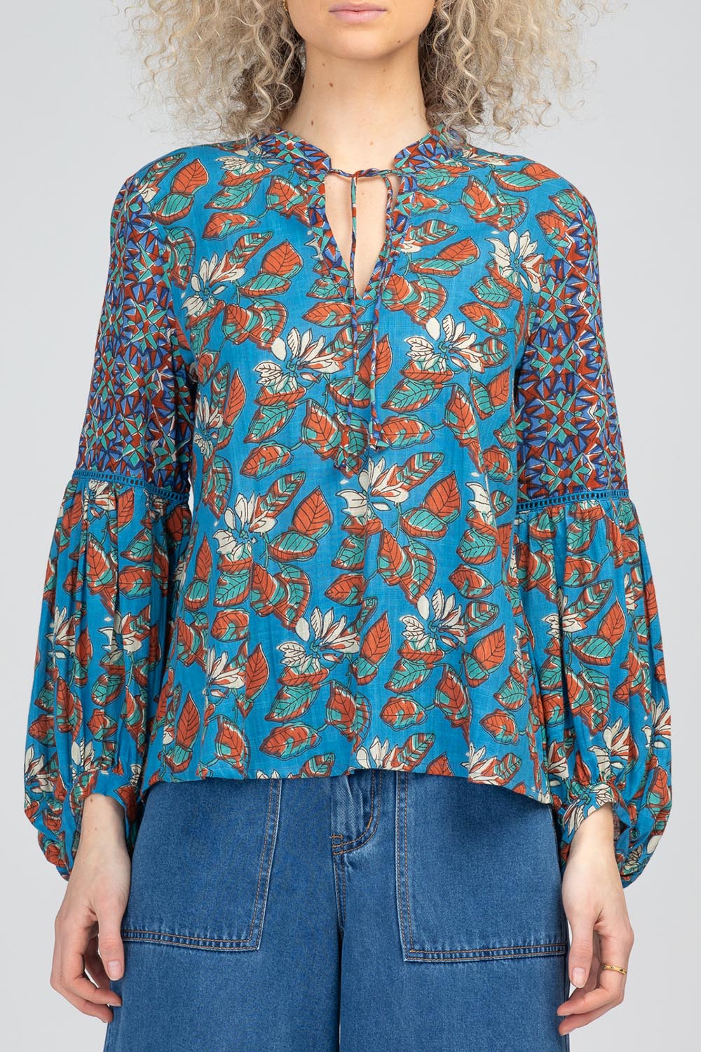 A model wearing the Mittie Cotton Top in colour Lettie (Blue), from the front, cropped image