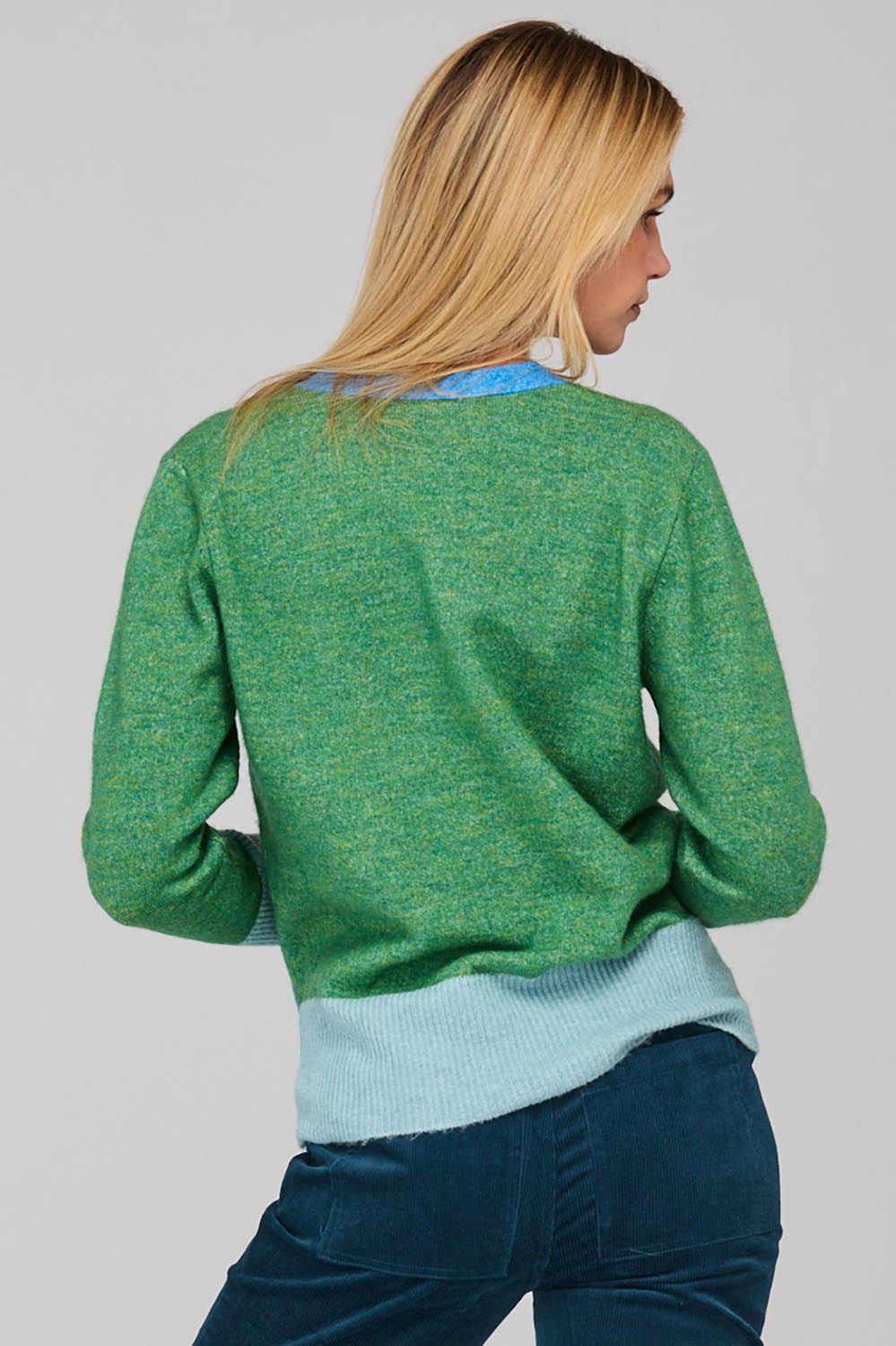 A model wearing the Poet Cardigan in colour Green (Green), from the back