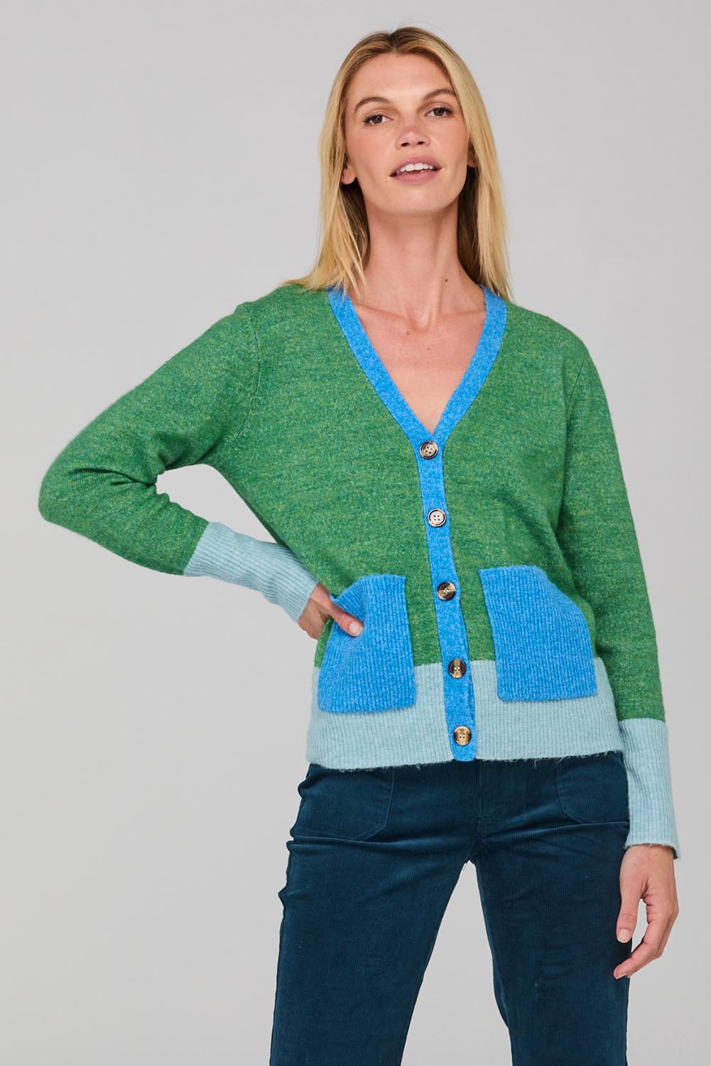 A model wearing the Poet Cardigan in colour Green (Green), from the front, cropped image