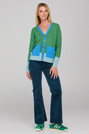 A model wearing the Poet Cardigan in colour Green (Green), from the front, showing the whole outfit