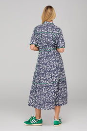 A model wearing the Rishi Dress in colour Izuminavy (Blue), from the back