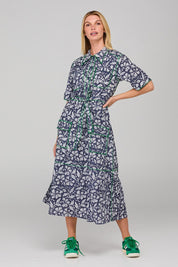 A model wearing the Rishi Dress in colour Izuminavy (Blue), from the front, showing the whole outfit