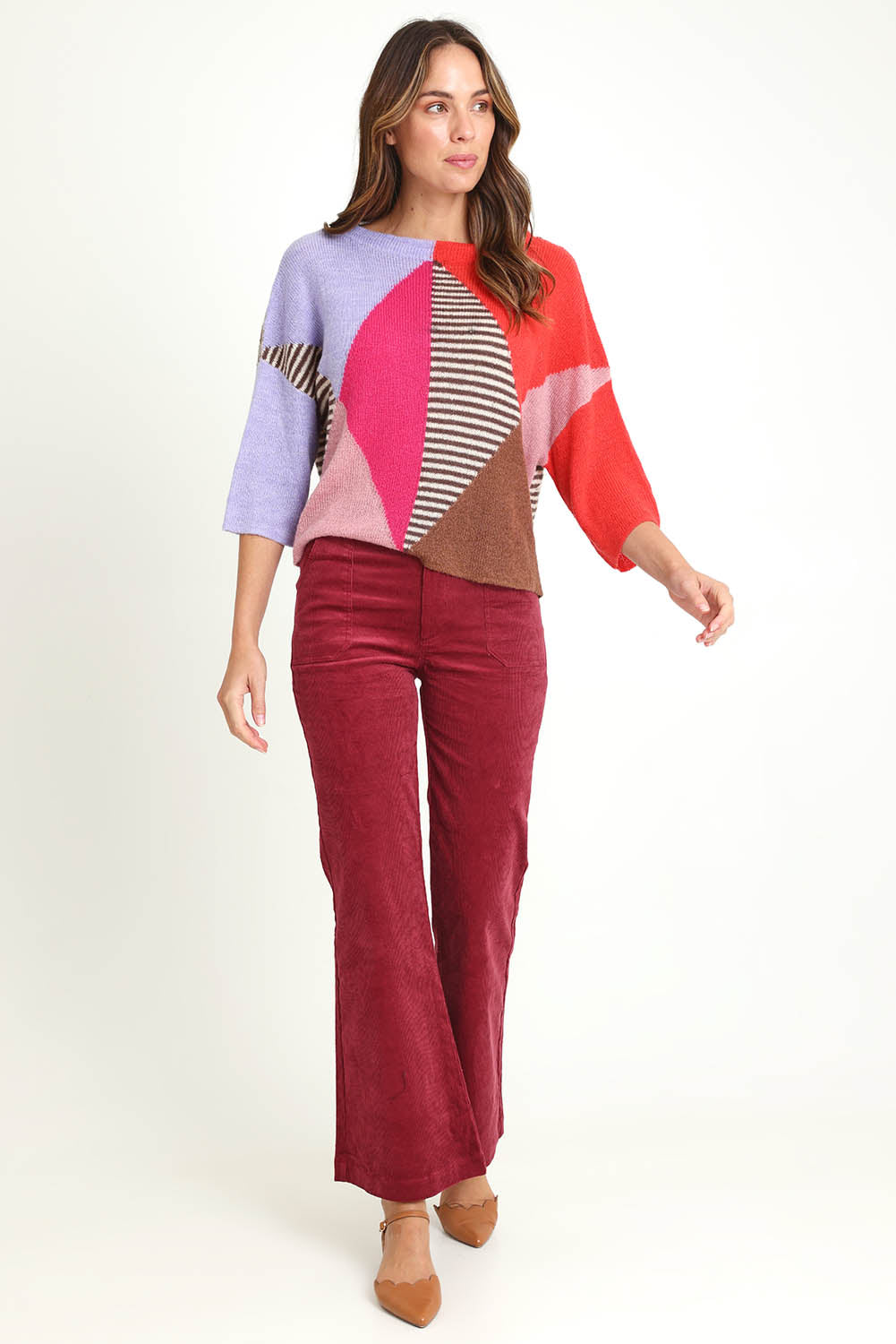 Model Madeline wearing size 10 of the Dharma Pant in colour Cranberry (Red), from the front, showing the whole outfit