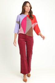 Model Madeline wearing size 10 of the Dharma Pant in colour Cranberry (Red), from the front, showing the whole outfit