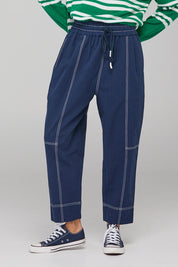 A model wearing the Jonte Pant in colour Navy (Blue), from the front, cropped image