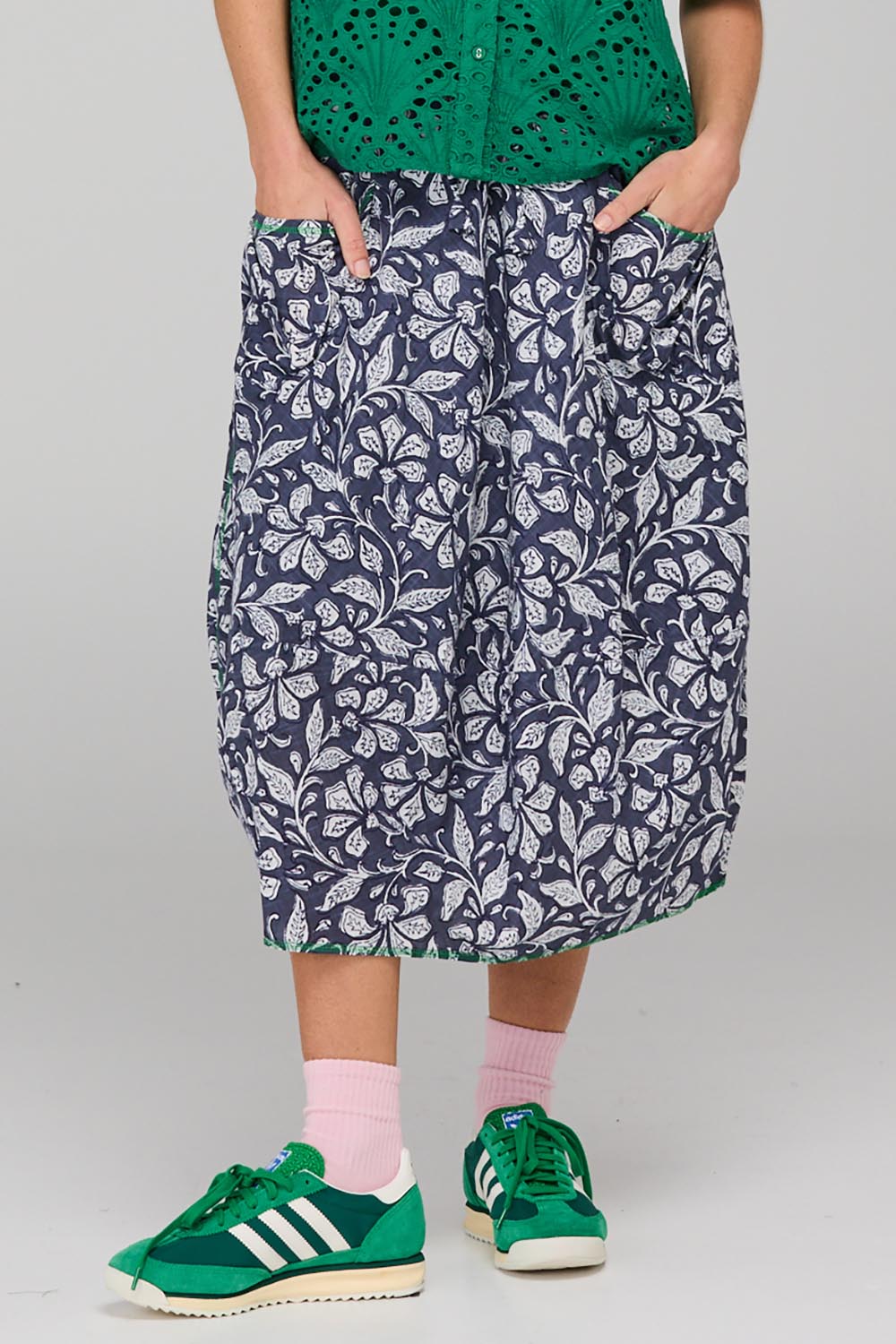 A model wearing the Guru Skirt in colour Izuminavy (Blue), from the front, cropped image