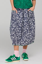 A model wearing the Guru Skirt in colour Izuminavy (Blue), from the front, cropped image
