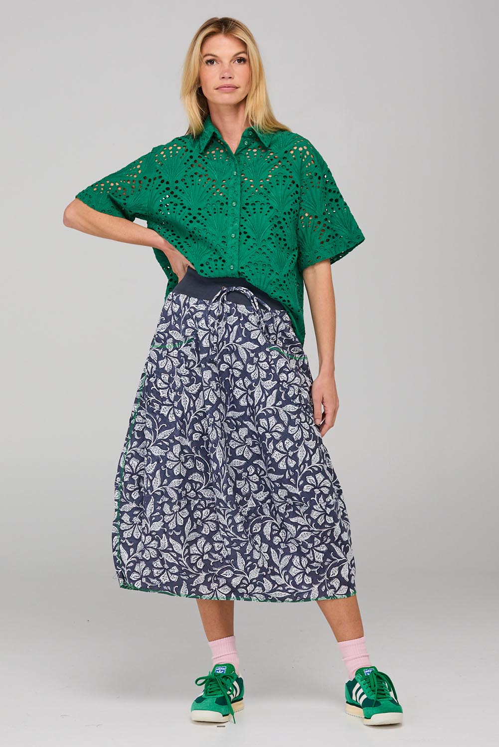 A model wearing the Guru Skirt in colour Izuminavy (Blue), from the front, showing the whole outfit