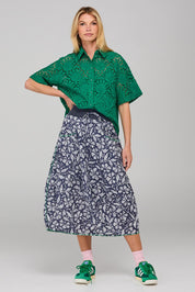 A model wearing the Guru Skirt in colour Izuminavy (Blue), from the front, showing the whole outfit