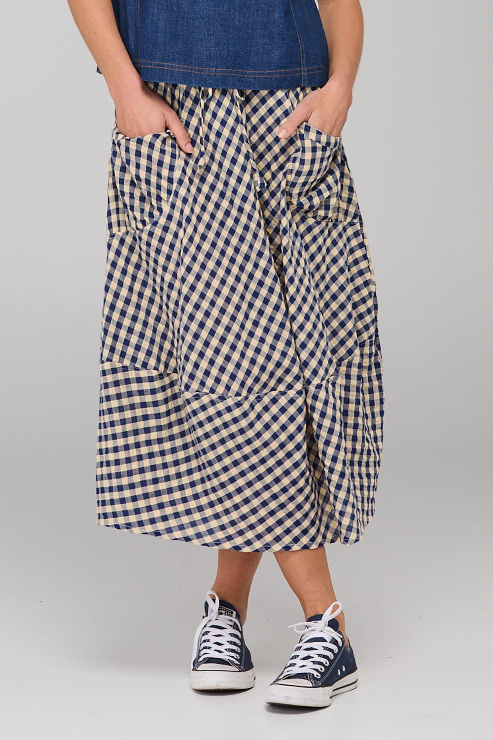 A model wearing the Guru Skirt in colour Navyseer (Blue), from the front, cropped image