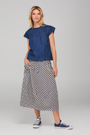A model wearing the Guru Skirt in colour Navyseer (Blue), from the front, showing the whole outfit