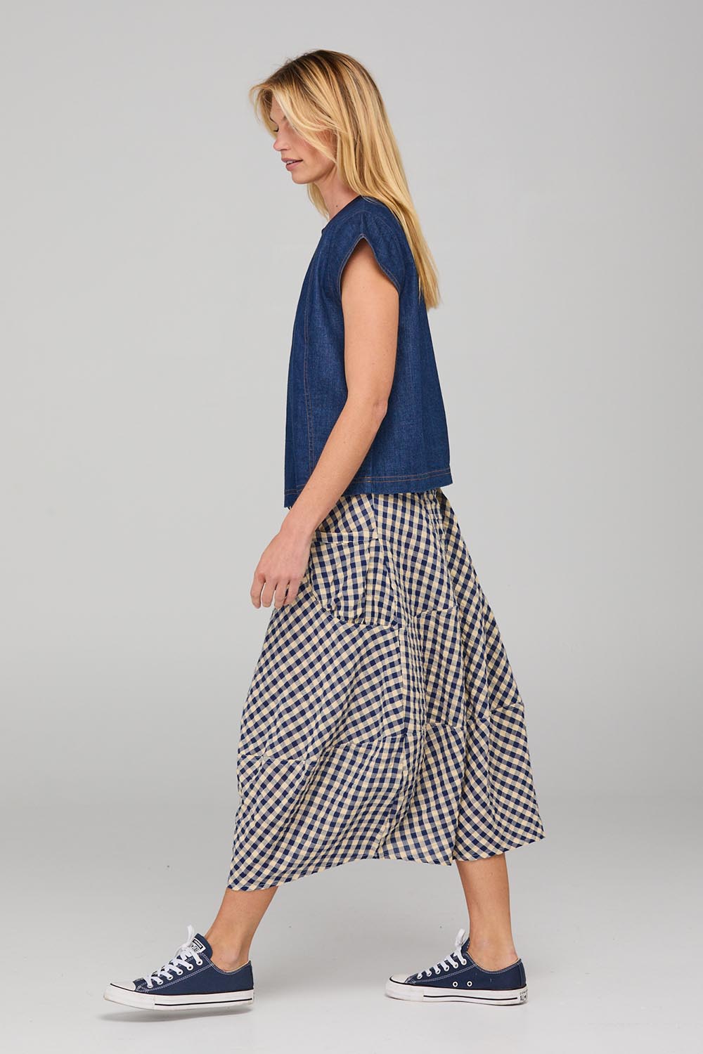 A model wearing the Guru Skirt in colour Navyseer (Blue), from the front, showing the whole outfit