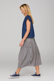 A model wearing the Guru Skirt in colour Navyseer (Blue), from the front, showing the whole outfit