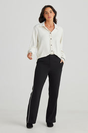 A model wearing the Blake Pant in colour Black (Black), from the front, showing the whole outfit