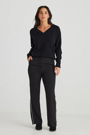 A model wearing the Blake Pant in colour Black (Black), from the front, showing the whole outfit