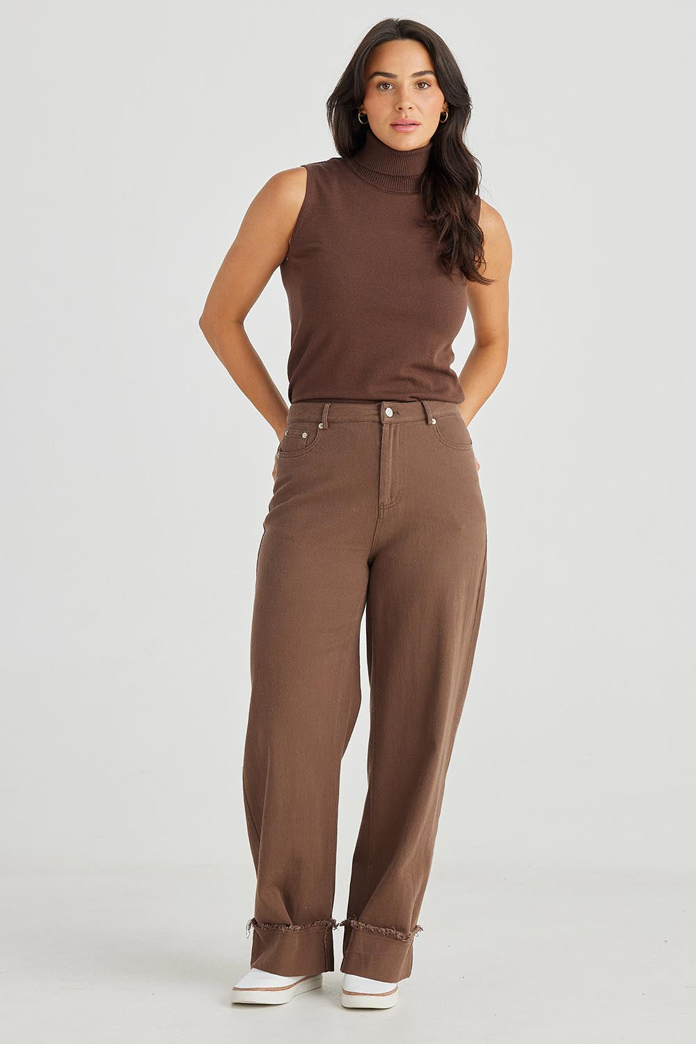 A model wearing the Leroy Pant in colour Chocolate, from the front, showing the whole outfit