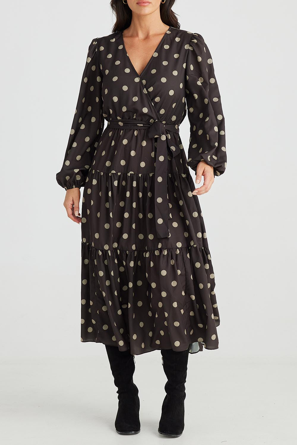 A model wearing the Zion Dress in colour Stonespot (Black), from the front, cropped image