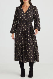 A model wearing the Zion Dress in colour Stonespot (Black), from the front, cropped image