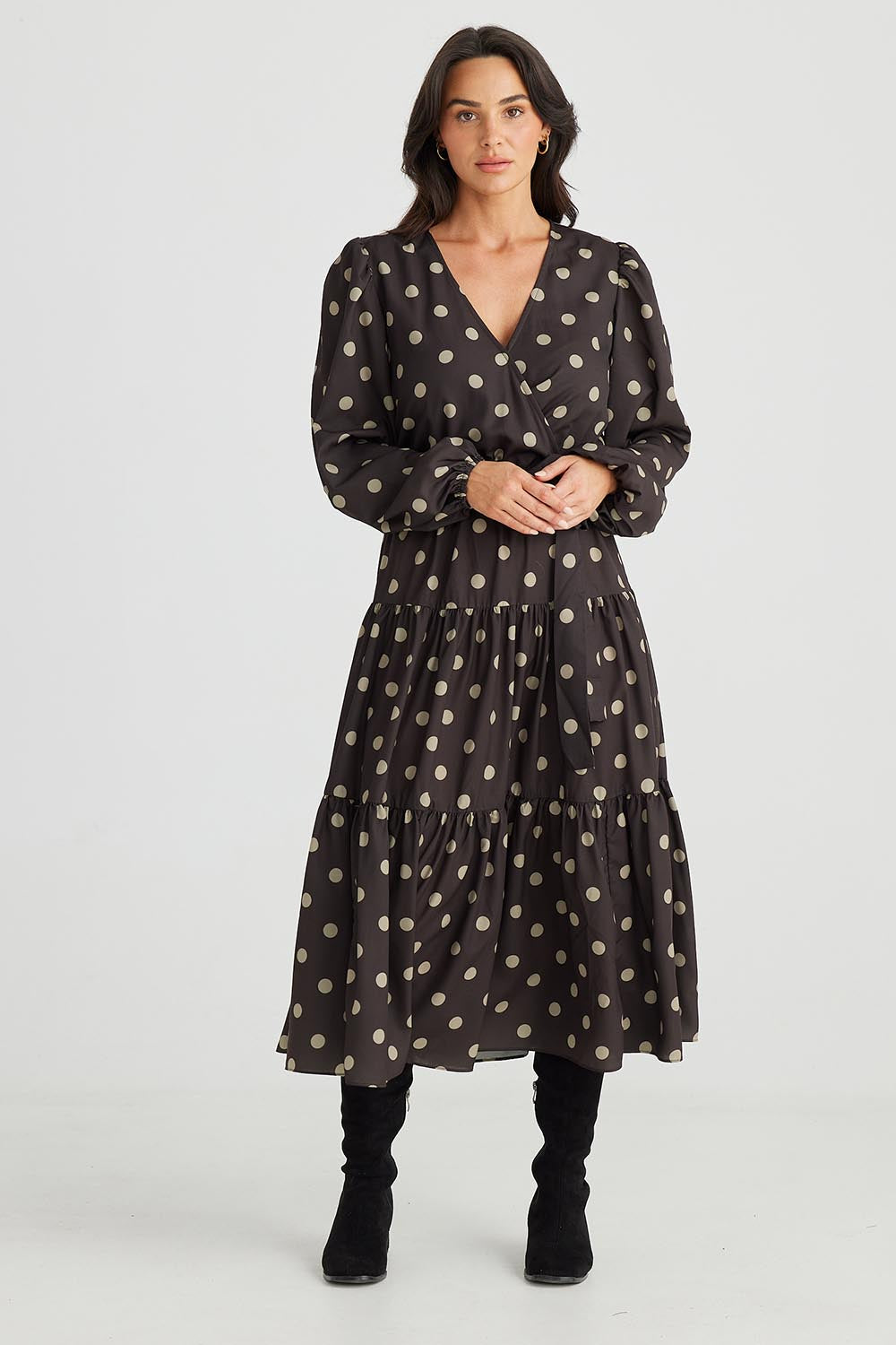A model wearing the Zion Dress in colour Stonespot (Black), from the front, showing the whole outfit