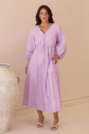 A model wearing the Daylight Cotton Dress in colour Lilac (Purple), from the front, showing the whole outfit