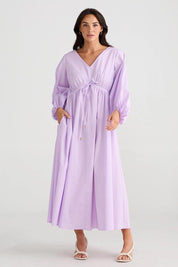 A model wearing the Daylight Cotton Dress in colour Lilac (Purple), from the front, showing the whole outfit
