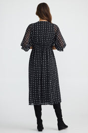 A model wearing the Parkside Dress in colour Arches (Black), from the back