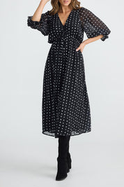 A model wearing the Parkside Dress in colour Arches (Black), from the front, cropped image