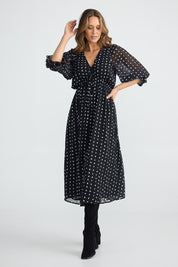 A model wearing the Parkside Dress in colour Arches (Black), from the front, showing the whole outfit