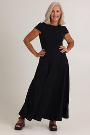 Model Sandy wearing size S of the Sylvie Cotton Dress in colour Black (Black), from the front, showing the whole outfit