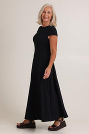 Model Sandy wearing size S of the Sylvie Cotton Dress in colour Black (Black), from the front, showing the whole outfit
