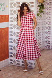 A model wearing the Musings Cotton Dress in colour Redgingham (Red), from the front, showing the whole outfit