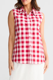A model wearing the Poppy Sleeveless Cotton Shirt in colour Redgingham (Red), from the front, showing the whole outfit