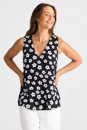 A model wearing the Veronica Top in colour Distydaisy (Black), from the front, cropped image