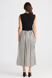 A model wearing the Daphne Dress in colour Blackstrip, from the back