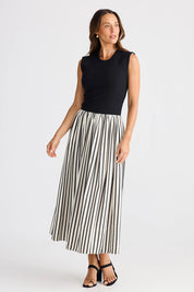 A model wearing the Daphne Dress in colour Blackstrip, from the front, showing the whole outfit