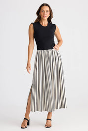 A model wearing the Daphne Dress in colour Blackstrip, from the front, showing the whole outfit