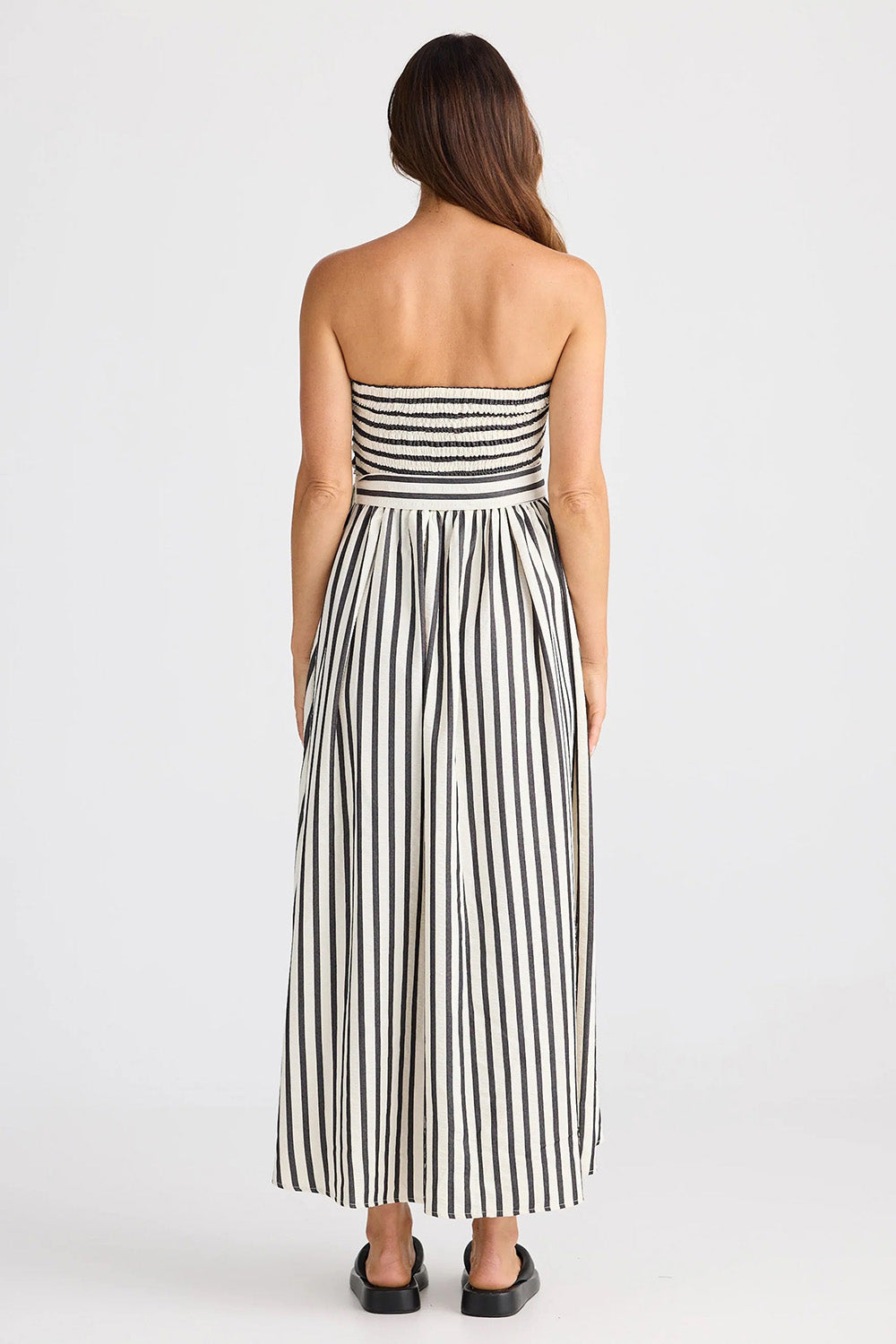 A model wearing the Avalon Dress in colour Blackstrip, from the back
