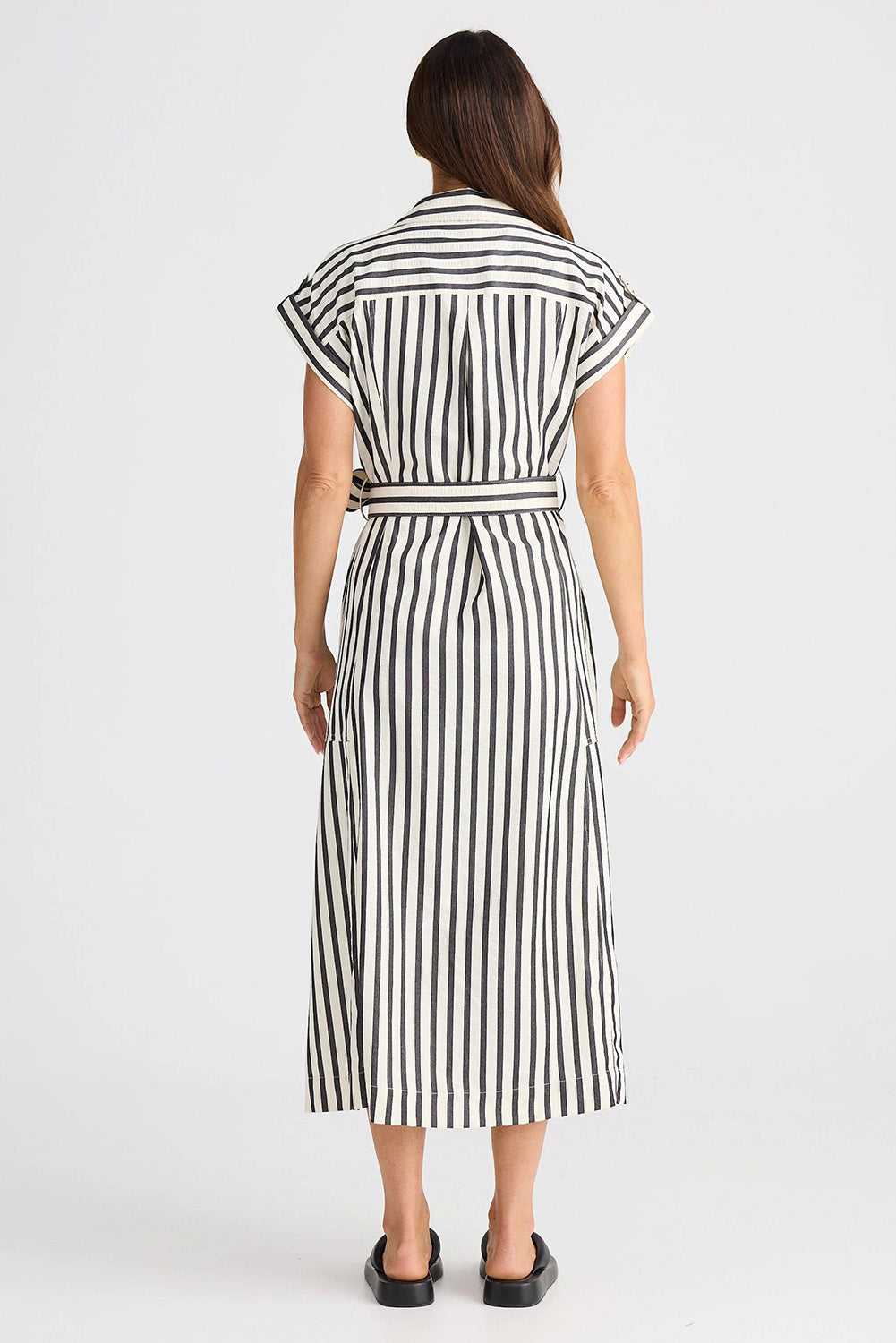 A model wearing the Portia Dress in colour Blackstrip, from the back