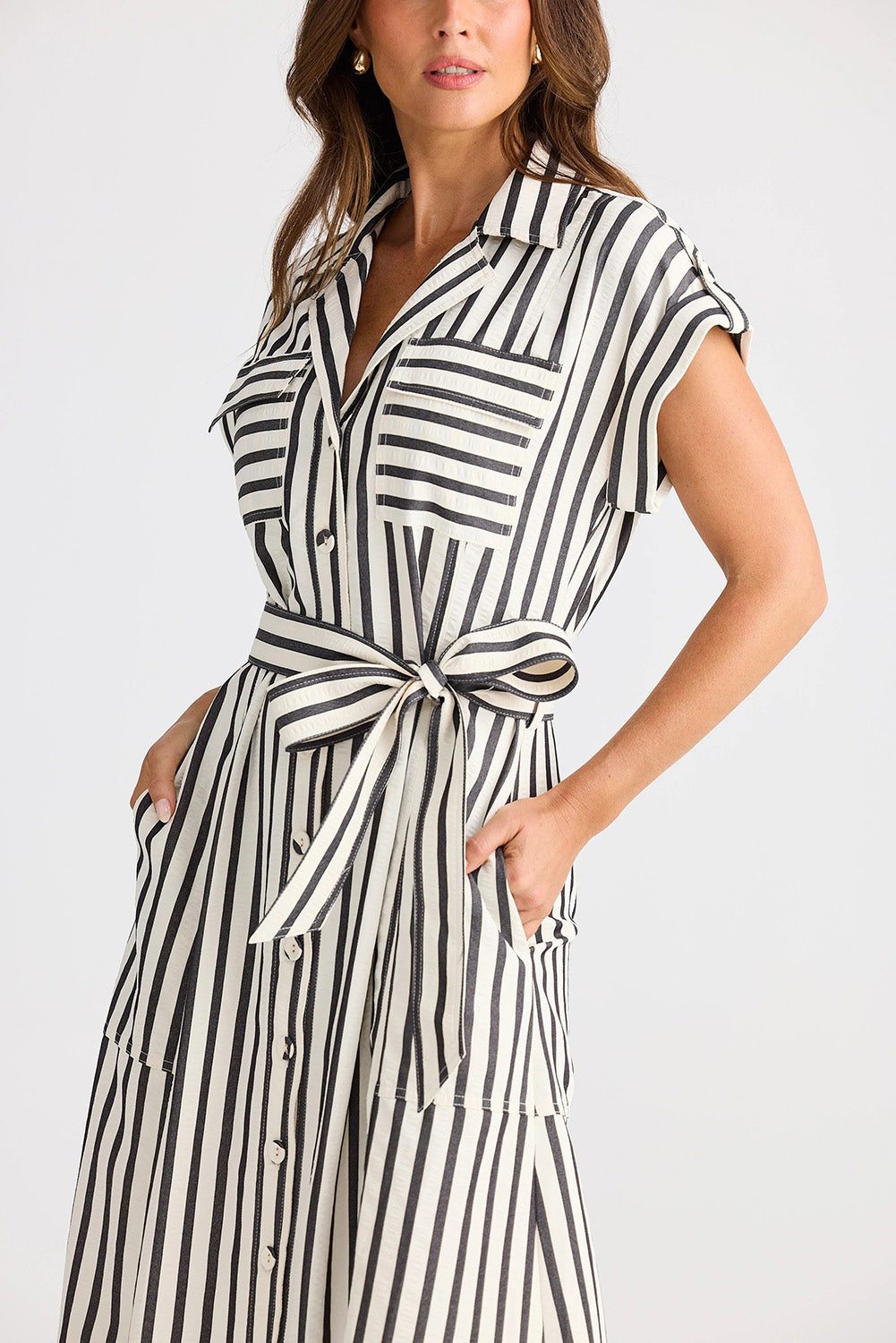 A model wearing the Portia Dress in colour Blackstrip, from the front, cropped image