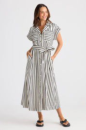 A model wearing the Portia Dress in colour Blackstrip, from the front, showing the whole outfit