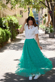 A model wearing the Chance Skirt in colour Jade (Green), from the front, showing the whole outfit