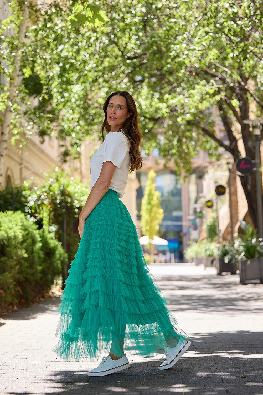 A model wearing the Chance Skirt in colour Jade (Green), from the front, showing the whole outfit