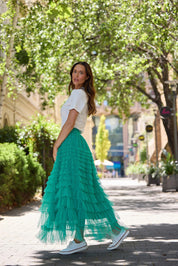A model wearing the Chance Skirt in colour Jade (Green), from the front, showing the whole outfit