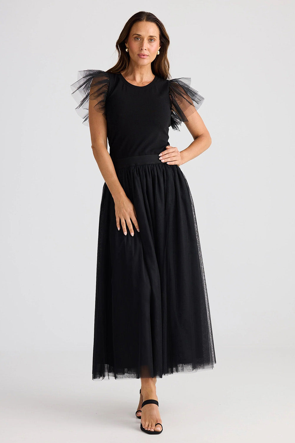 A model wearing the Carrie Skirt in colour Black (Black), from the front, showing the whole outfit
