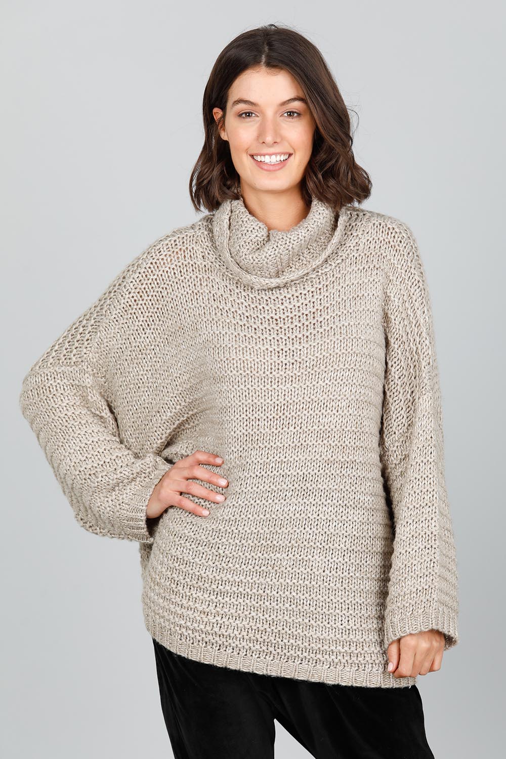 A model wearing the Saffron Knit in colour Cement (Grey), from the front, cropped image