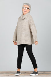 A model wearing the Saffron Knit in colour Cement (Grey), from the front, showing the whole outfit