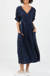 A model wearing the Pansies Wrap Dress in colour Navy (Blue), from the front, cropped image