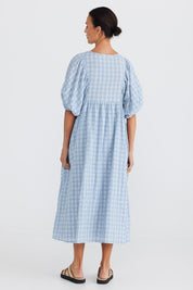 A model wearing the Ciao Bella Dress in colour Bluecheck (Blue), from the back