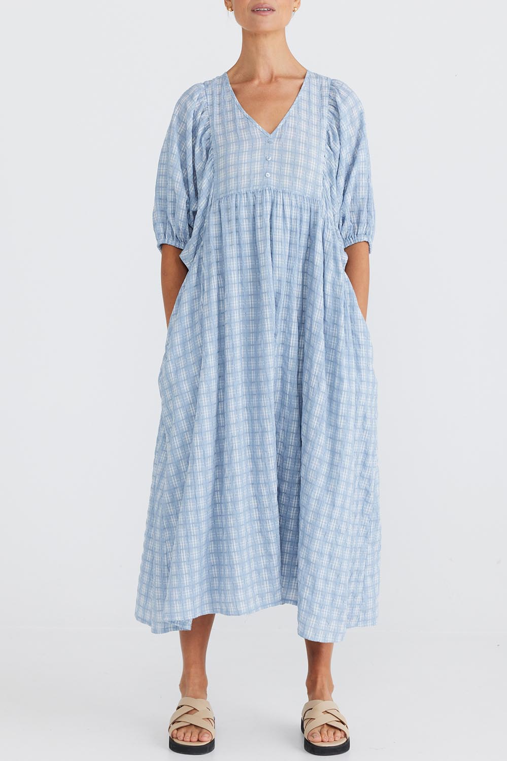 A model wearing the Ciao Bella Dress in colour Bluecheck (Blue), from the front, cropped image