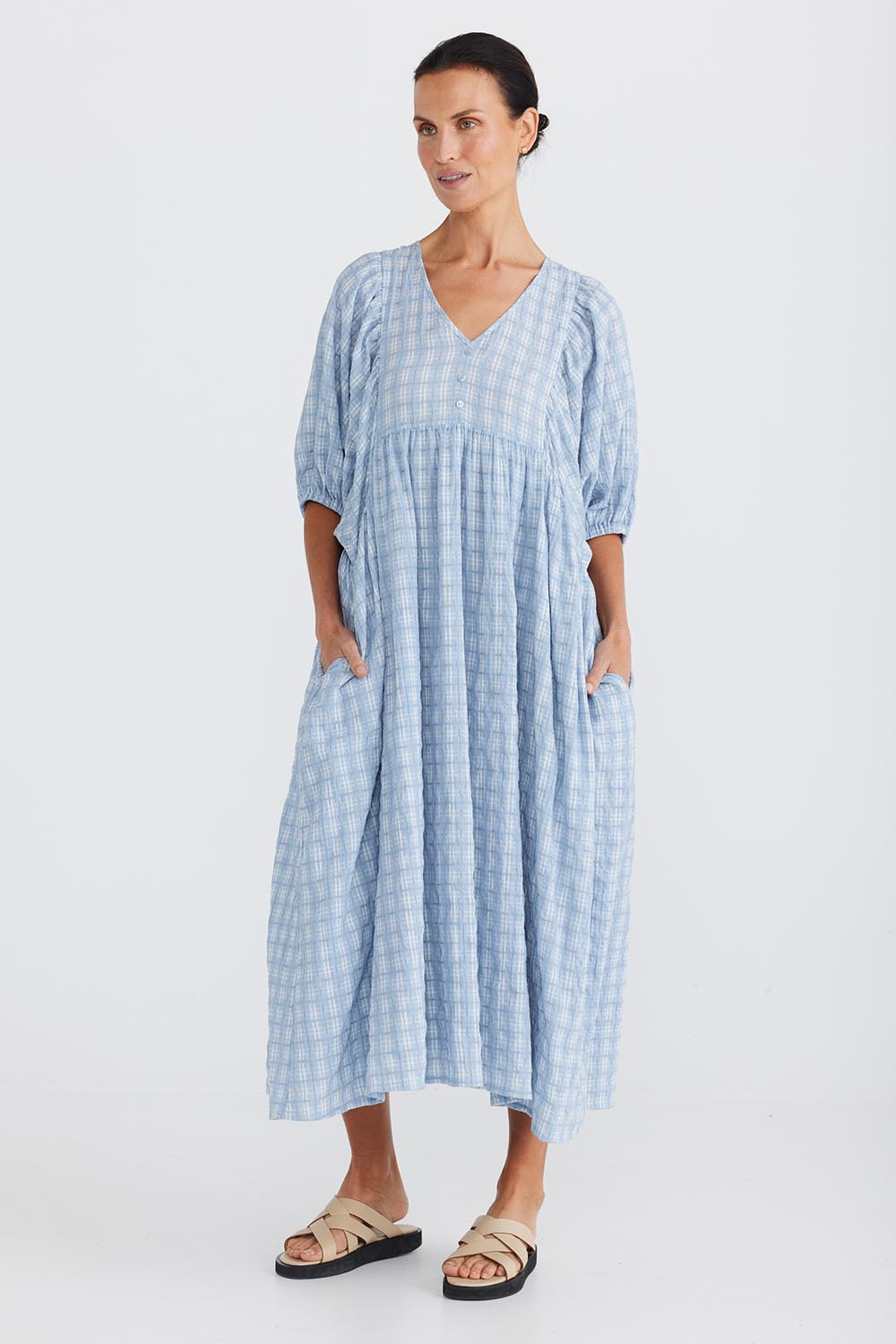 A model wearing the Ciao Bella Dress in colour Bluecheck (Blue), from the front, showing the whole outfit
